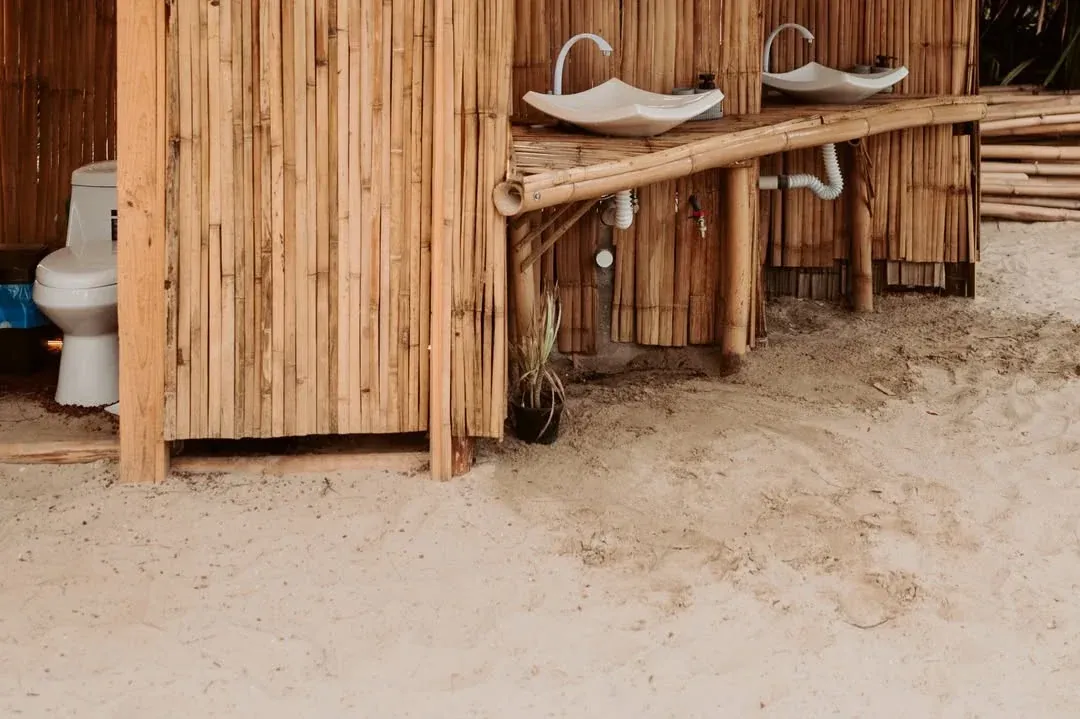 Shared bamboo bathrooms and showers, with stone basins and wooden finishes