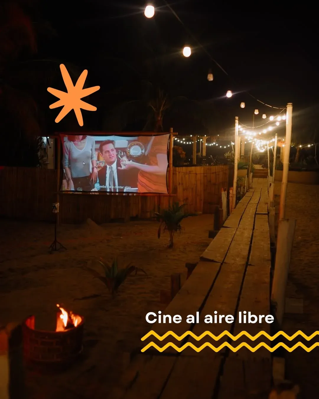 The open-air cinema screen among the bamboo, with string lights over the walkway