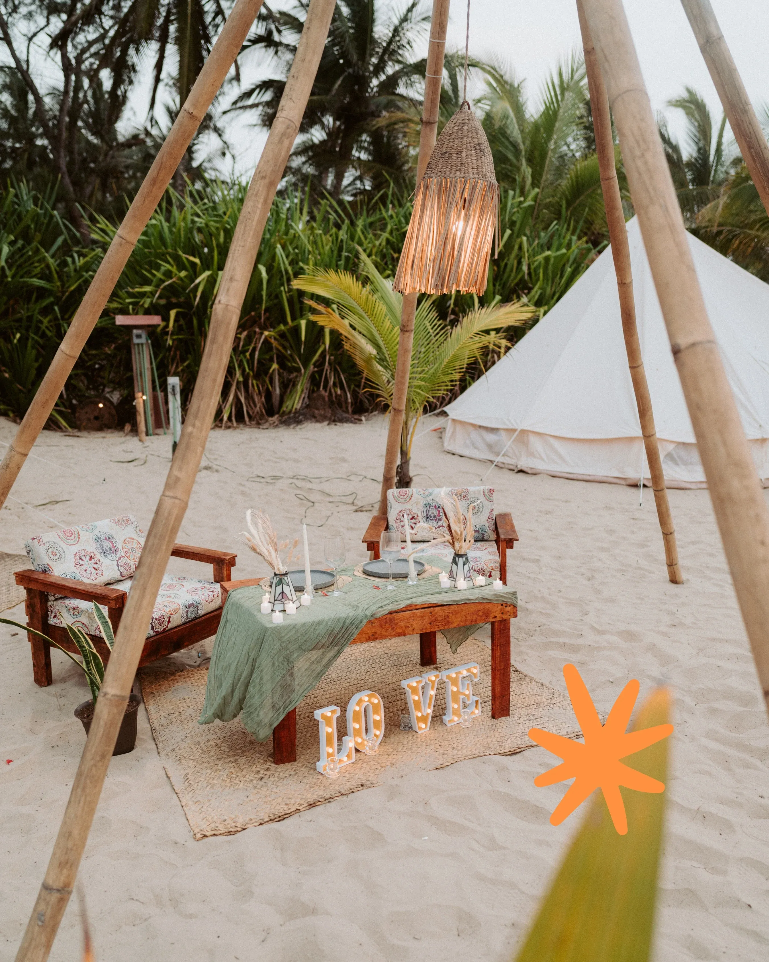 Rondo Love setup: a dressed table, candles and LOVE letters in front of the tent