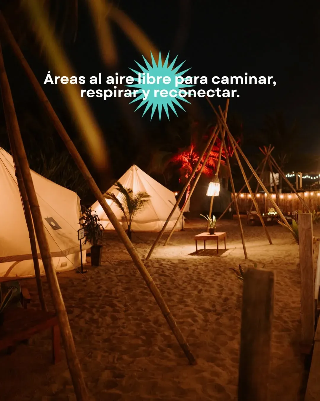 The camp at night: lit tents and string lights hung along the walkways